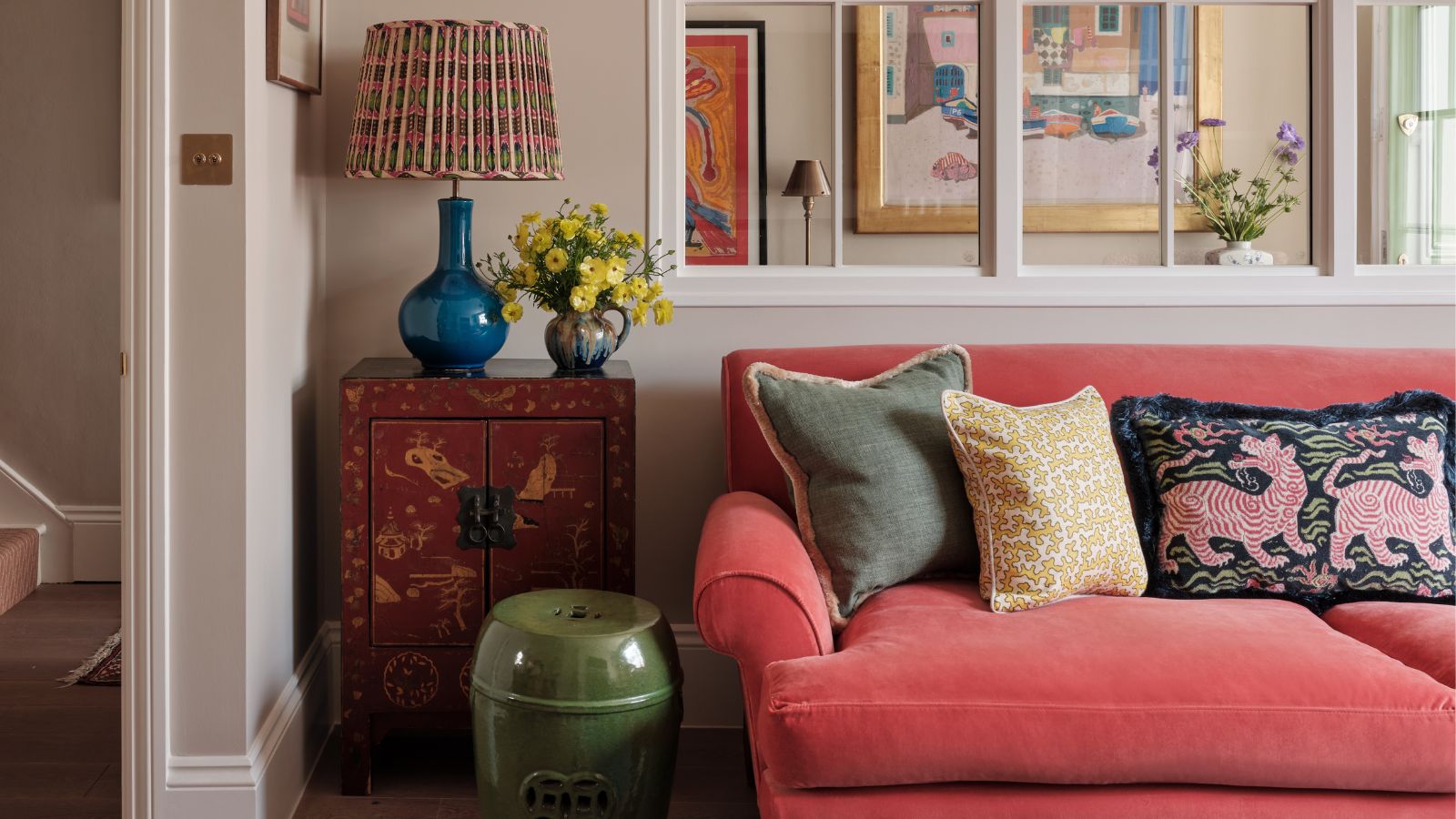 Neutral living room with coral velvet sofa and colorful accents