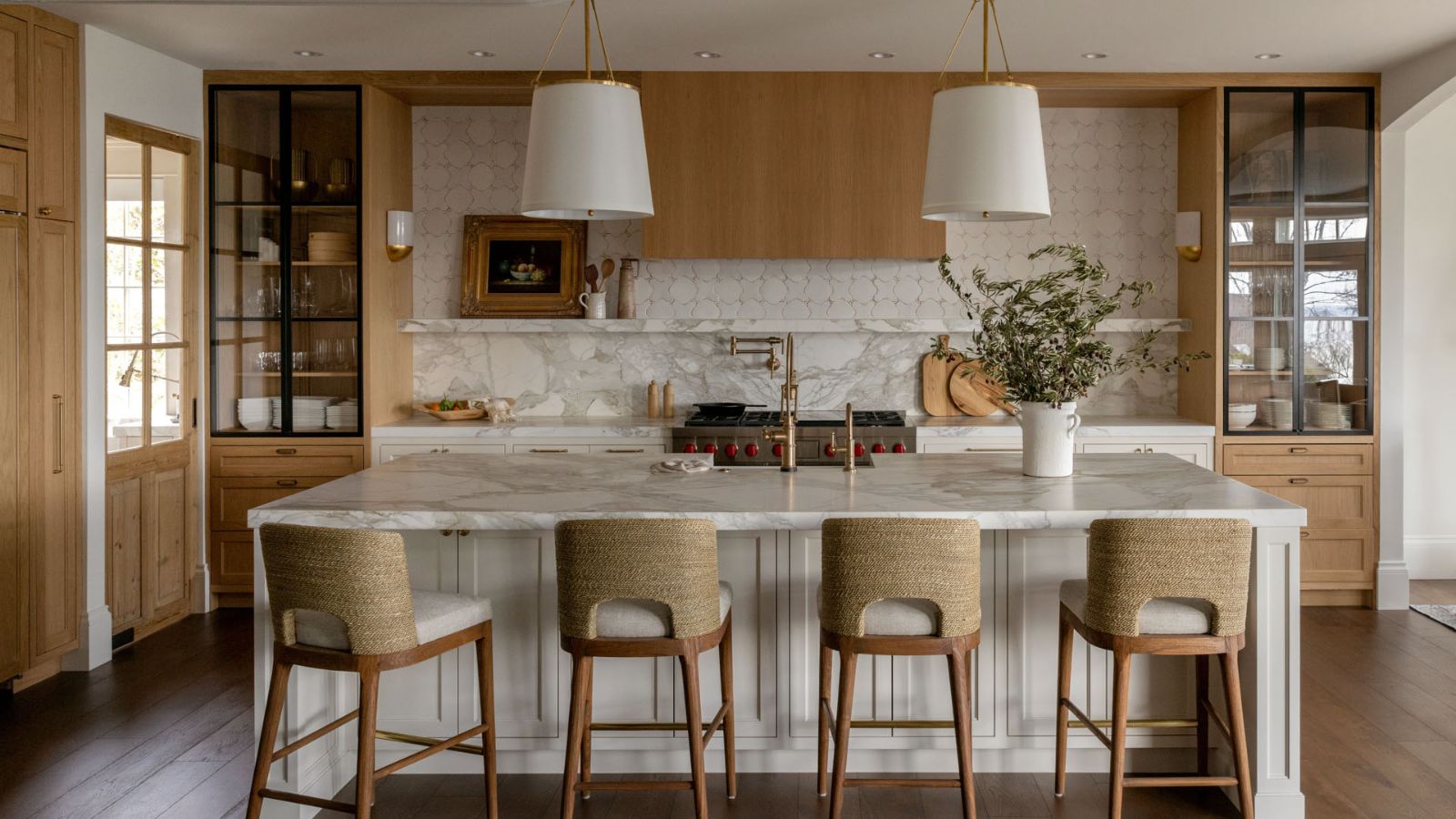 A warm neutral kitchen with wooden cabinets, a marble countersplash, and wall tiles to extend the backsplash