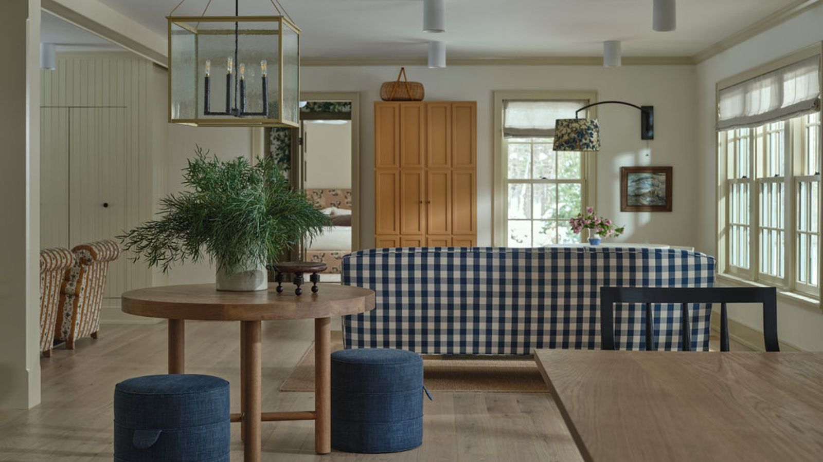 An open plan living and dining area with a blue and white checkered sofa